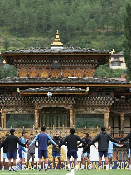 The team huddles in front of a traditional Bhutanese building, blending sport and culture. This image captures a unique moment of unity and focus during our international camp.