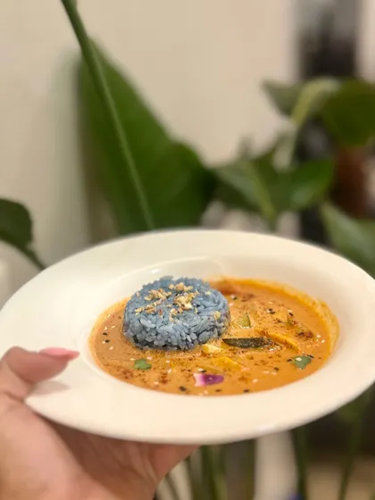 A comforting bowl of Thai Penang Coconut Lime Curry, served with a mound of our signature blue pea flower rice.