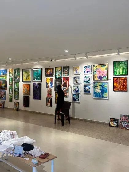 An artist sets up her work for a group exhibition at our gallery. We provide a professional and supportive space for artists to display their creations.
