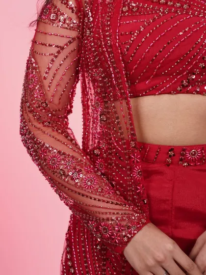 A close-up of the sleeve on the red three-piece set's jacket. The detailed sequin and beadwork is what makes this outfit so special.