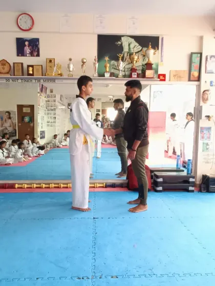 A student receives his yellow and green belt.