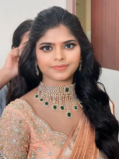 Anitha on her reception day. This stunning peach look is modern and fresh, with a focus on a flawless base and defined eyes.