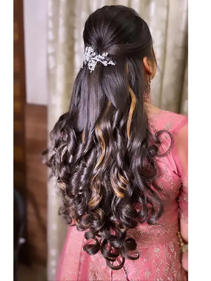 A half-updo with a simple twist and soft curls, accented with a sparkling leaf-design hair clip. This is a versatile look that works for engagements, receptions, or even for bridesmaids.
