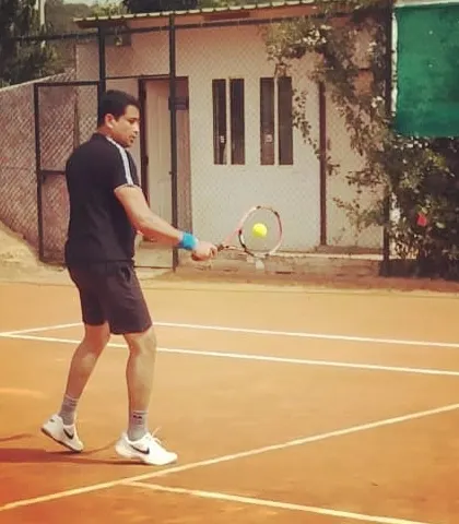 A player prepares to hit a backhand during a Tennis360 UTR Tour match, showcasing his ready stance.