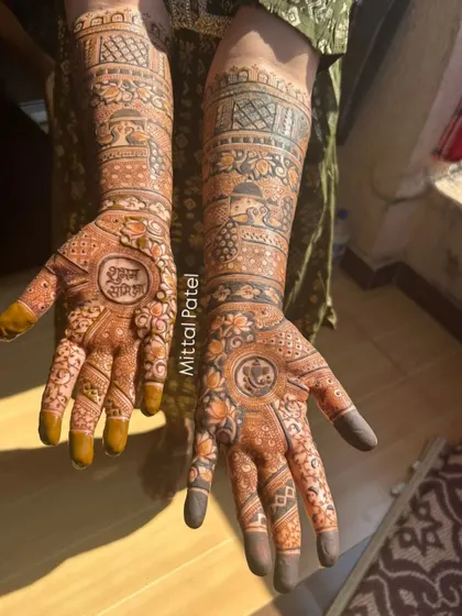 A sun-kissed photo of a bridal mehndi, featuring "Shubh Labh" (auspicious gains) and a Ganesha motif for good luck.