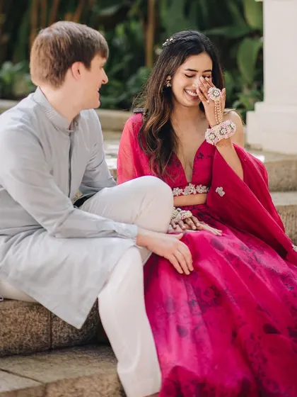 Laughter and love. This couple shares a sweet moment during their Haldi. Her pink lehenga and his light blue kurta create a beautiful, soft color palette.