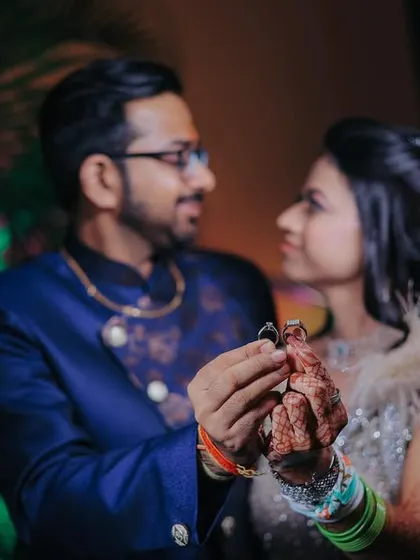 A creative shot focusing on the couple holding their engagement rings. This highlights the central theme of the ceremony in a unique way.