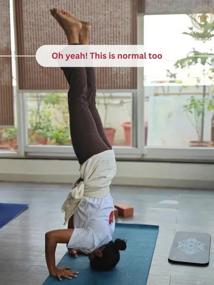 "Oh yeah! This is normal too." A student casually holds Sirsasana, showcasing that with dedication, extraordinary poses become part of the everyday practice at Aikia.