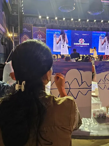 A participant fully immersed in painting her canvas during one of my large corporate events. I make sure everyone, from absolute beginners to seasoned artists, feels comfortable and has a great time.
