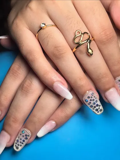 The complete look, showing the balance between the simple white ombré and the dazzling stone accent nails.