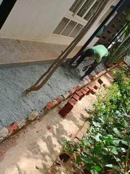 Leveling the base material right up to the brick border for a seamless edge.