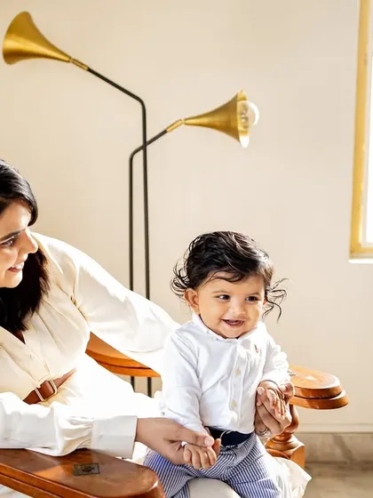 A mother and her baby sharing a happy moment in a classic wooden chair. I love finding unique spots in your home that make for beautiful portraits.