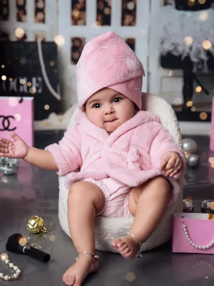 Posing with attitude! This 4-month-old is already a pro in front of the camera in her fluffy pink robe.