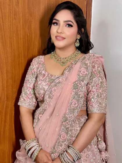A beautiful and soft sagan makeup look. The focus is on flawless skin and rosy tones, which look stunning with her pastel pink embroidered lehenga.