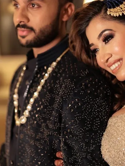 A romantic couple portrait from the Sangeet. The bride's makeup is soft and glowing, complementing her partner's classic look.