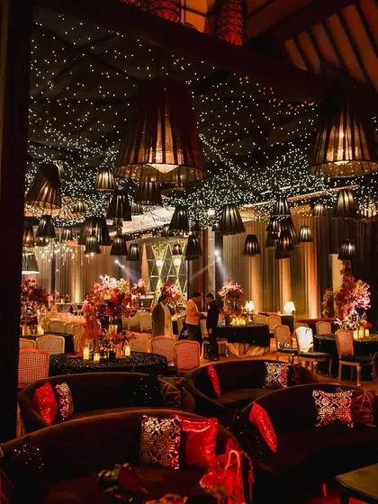 We create spaces that feel both grand and intimate. For this reception, we used heavy uplighting, lush floral centerpieces, and rich velvet seating to weave a tapestry of romance and radiant elegance.