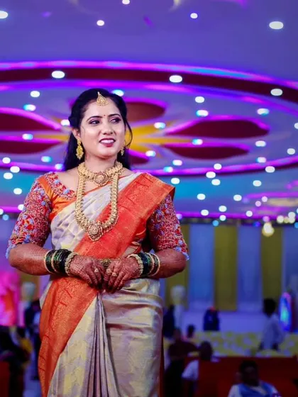 Standing beautifully at her reception venue. The makeup was designed to be visible and flawless even from a distance, with a focus on a radiant complexion and defined features.