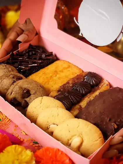 A look inside the Diwali Bliss Box, which contains Zesty Orange, Marble, Vanilla Rocher, and Chocolate Mud tea cakes, along with homemade Nankhatai and Belgian Chocolate Chunk cookies.