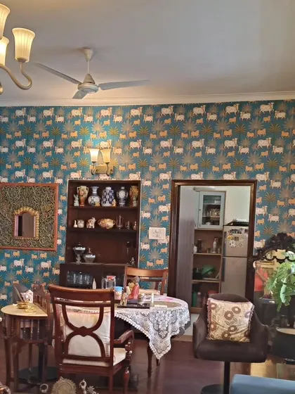 A unique wallpaper featuring a repeating cow pattern, in the style of Sabyasachi designs. This adds a quirky yet traditional Indian touch.