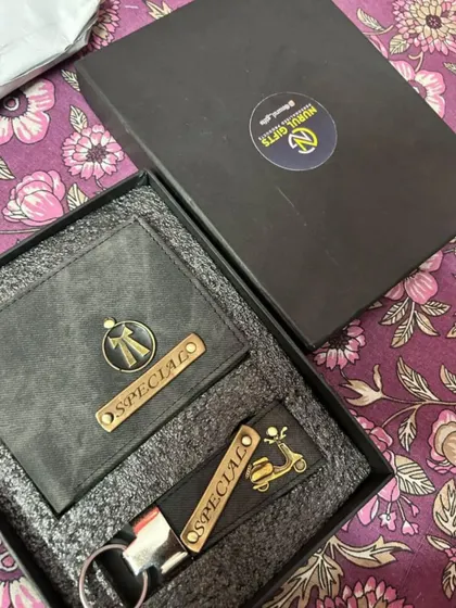 A personalized gift set in grey denim, this combo includes a wallet with a bow tie charm and a keychain with a scooter charm.