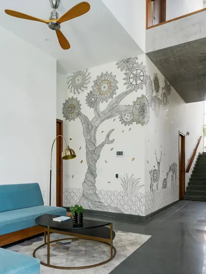 The informal lounge space features mid-century modern furniture and a custom mandala wall art that spans multiple floors, acting as the artistic core of the house.