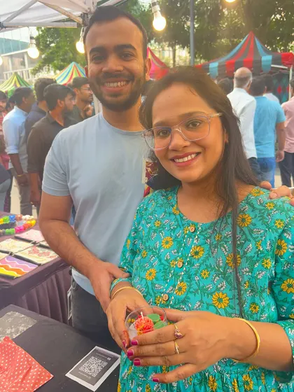 A couple smiles for a photo with the candle they crafted at our live event station.