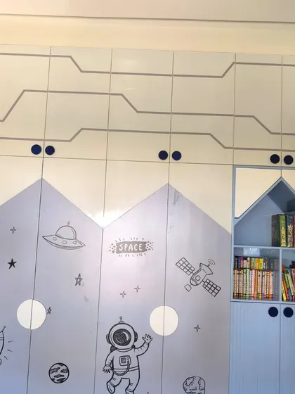 A custom space-themed wallpaper applied to a wardrobe, designed to look like a spaceship.