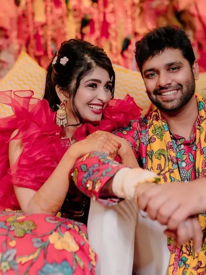 Fun and candid moments from a vibrant Mehendi event. The couple is sharing a laugh, surrounded by the bright, festive atmosphere I designed for their special day.