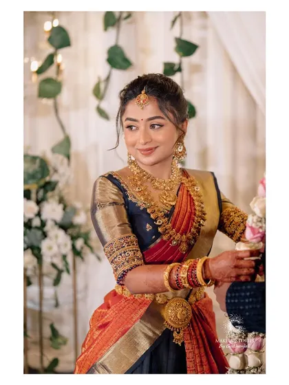The beautiful Harshitha for her engagement. This look features a classic South Indian style with gold jewelry and a soft, glowing makeup application.
