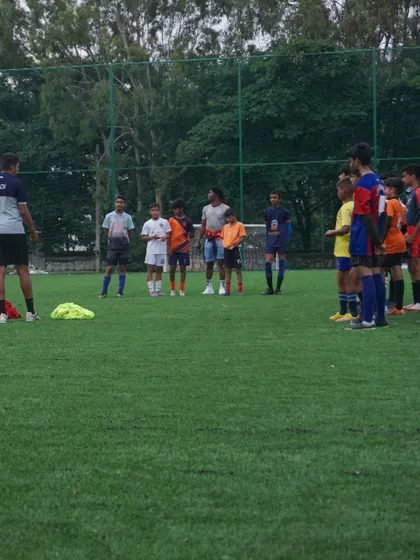 A smaller group of players receives specific instructions from a coach during a break in the trial matches.