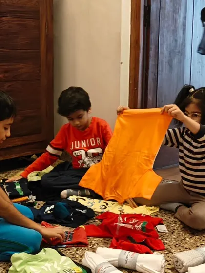 Sorting through donated clothes, children learn about the needs of others and the importance of giving.