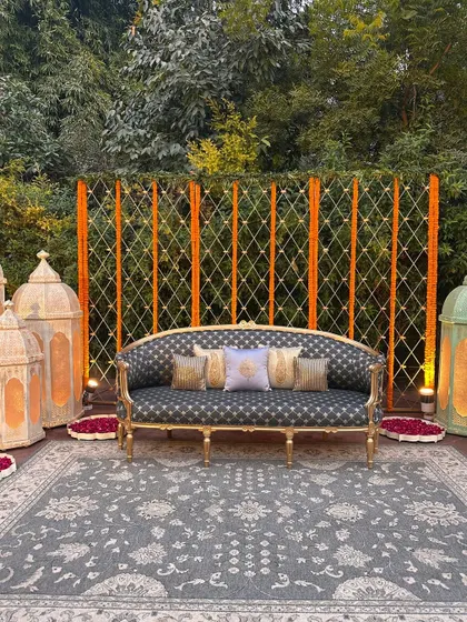 A regal seating area for the couple, with a backdrop of marigold strings and elegant Moroccan-style lanterns.