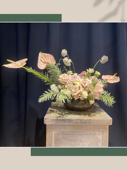 Floral design transforms nature's delicate beauty into captivating expressions. This arrangement showcases a modern, ikebana-inspired style with elegant anthuriums and roses.
