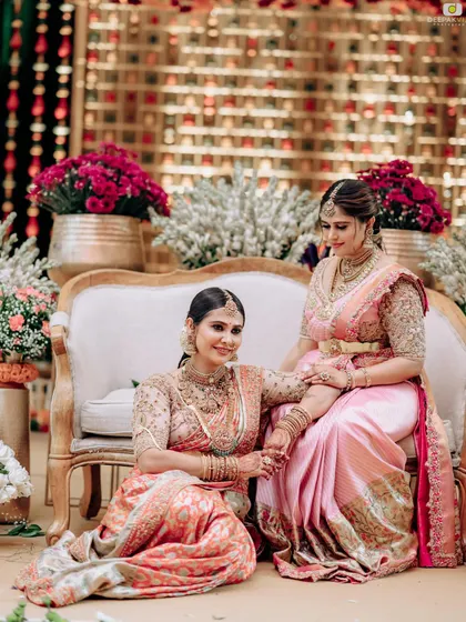 A classic portrait of two sisters in our custom sarees. The similar color palette and fabric create a harmonious look while allowing each sister's individual style to shine.