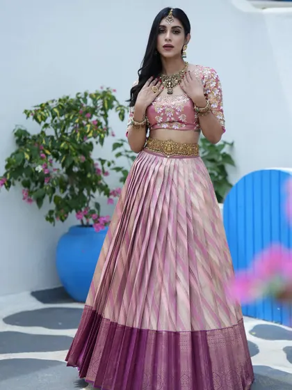 A closer look at the pink and gold half saree, showing the intricate hand embroidery on the blouse and the beautiful weave of the Kanchipuram silk.