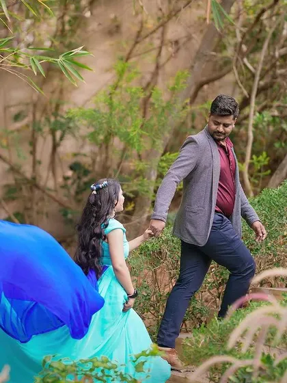 A romantic shot of a couple walking up a path, the bride's long dress trailing behind her.