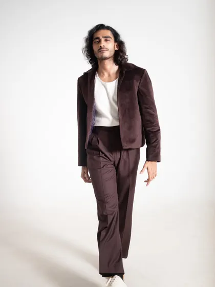 A walking shot of the brown velvet suit, showing how the fabric moves and catches the light.