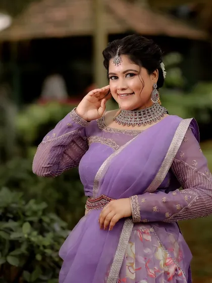 A modern take on the traditional half saree. This lavender ensemble features a floral print organza skirt and a sheer-sleeved blouse, perfect for an engagement or reception.