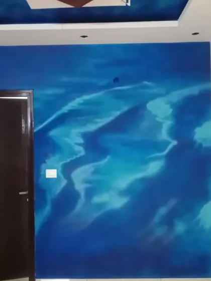 An abstract, free-flowing design in shades of blue, resembling ocean waves or a cloudy sky. This is a custom artistic finish for a truly unique accent wall.