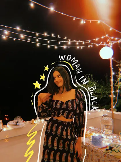 A woman in black at a party, with fairy lights and doodles to create a magical atmosphere.