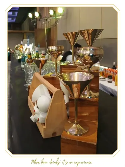 A close-up of our bar, showcasing premium metallic glassware and unique serving caddies. Every element is chosen to enhance the aesthetic and luxury feel of the event.