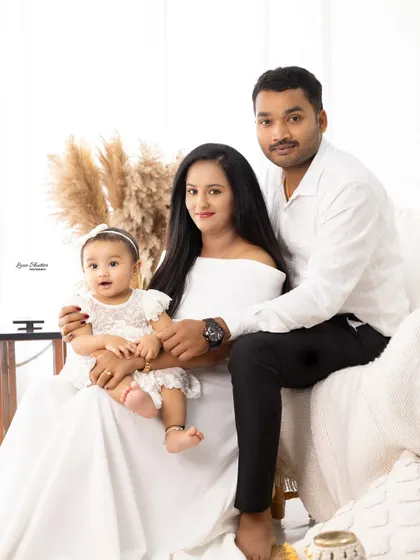 A relaxed family portrait in a boho-inspired setting. The family is sitting together, creating a warm and comfortable atmosphere.