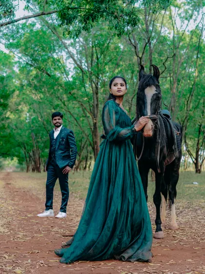A stunning wide-angle view of the couple's pre-wedding shoot with a horse, showcasing the beauty of the forest location.