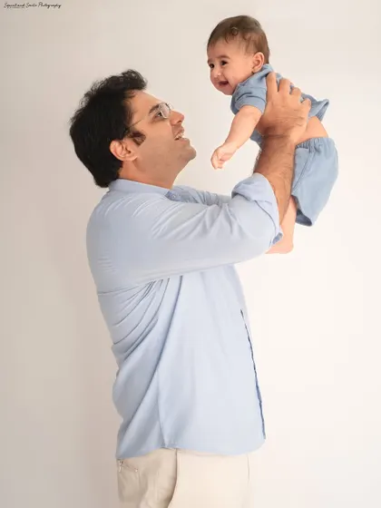 A father lovingly lifting his baby into the air. This classic pose always results in the biggest smiles and happiest giggles.