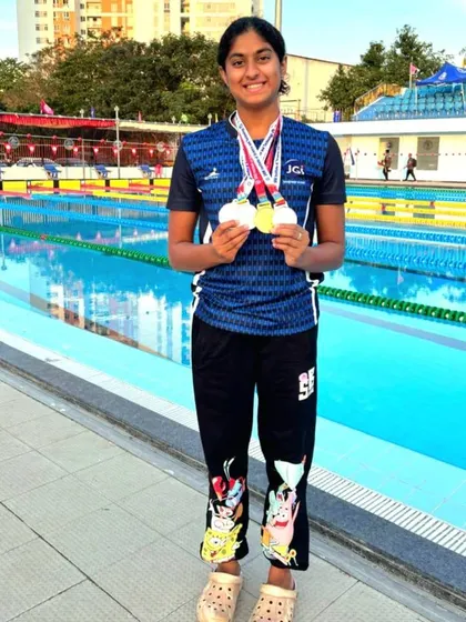 A full-length shot of Ashmitha Chandra with her impressive medal collection from the university-level swimming championship in Chennai.