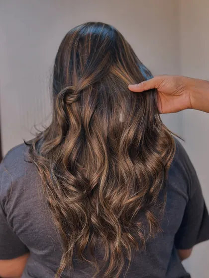 A close up on the revived warm tones. This balayage is perfect for adding richness and depth to brunette hair.