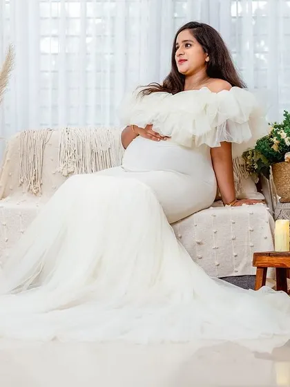 A confident and radiant portrait of the expecting mother on our boho-style couch. The entire setup is designed to be comfortable and beautiful.