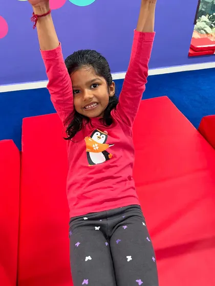 A happy gymnast ready for her next challenge. The joy and confidence that shine through after mastering a skill are what make our work so rewarding.