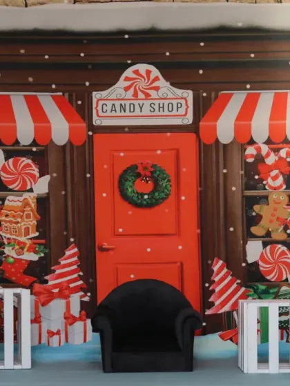 Our festive Christmas candy shop set, complete with striped awnings, gingerbread decorations, and a tiny armchair for the star of the show.