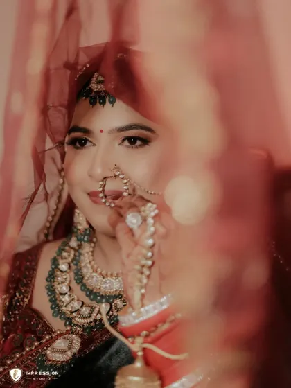 A creative shot of the bride seen through her red veil, creating a sense of mystery and anticipation.